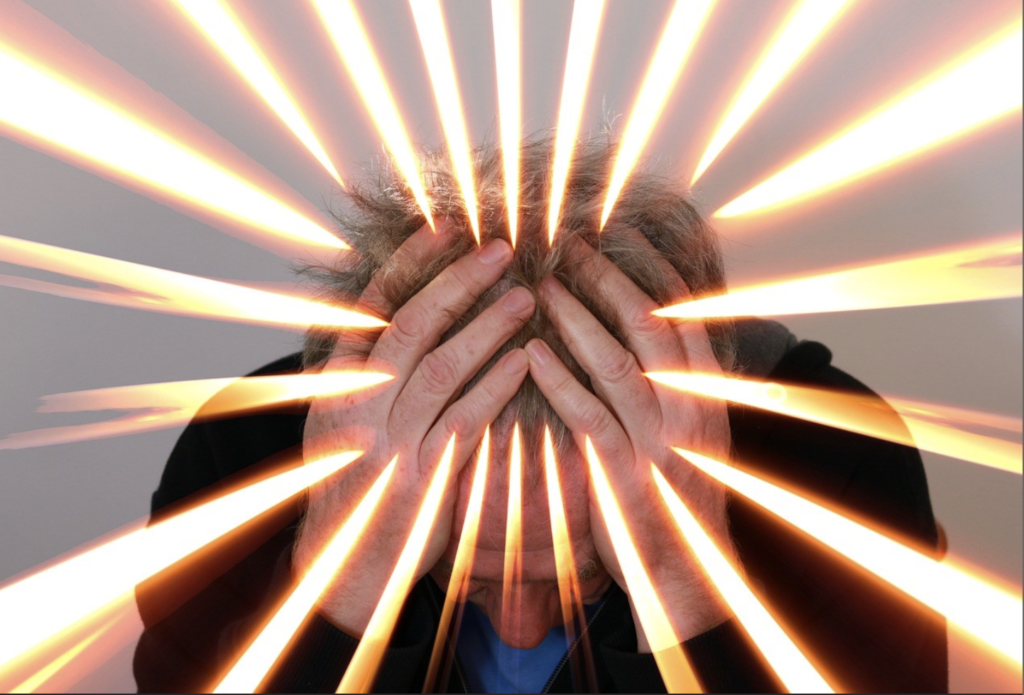 hands on head with light rays emanating