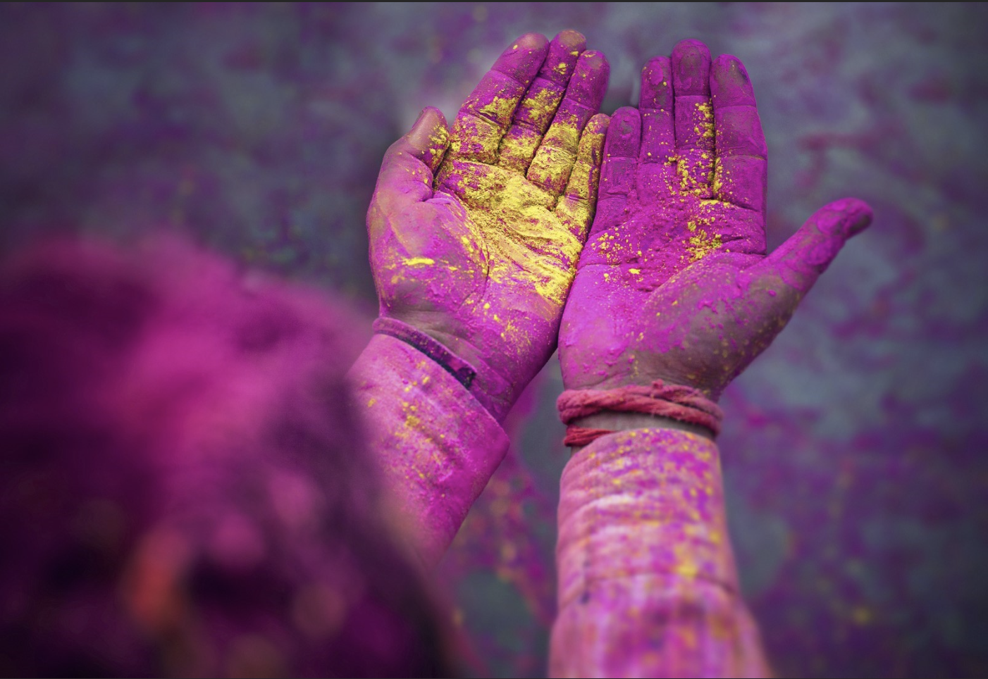 hands covered in color dust in clebration